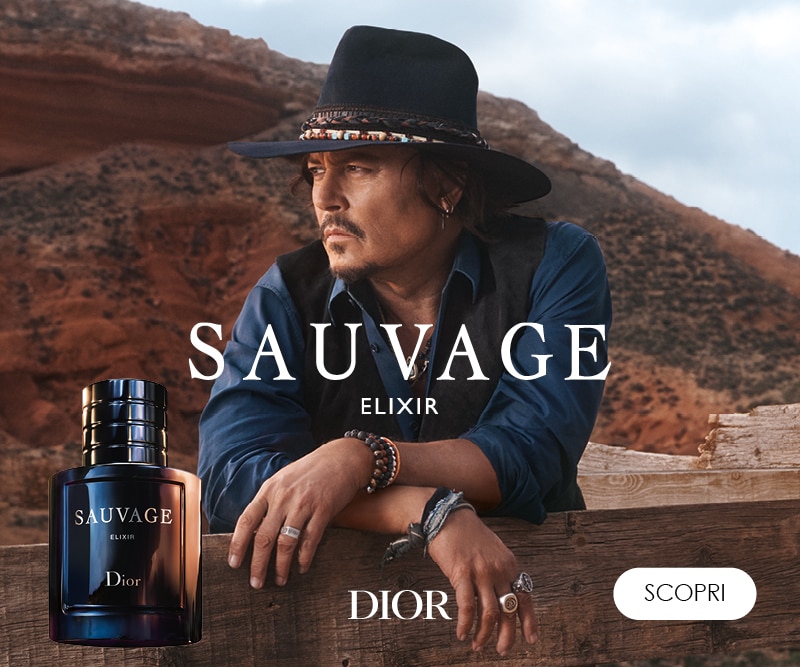 Dior Sauvage Elixir – testimonial maschile con cappello nero, sfondo desertico e flacone del profumo in primo piano.